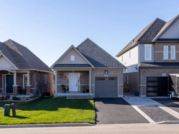 Detached homes with garages, driveways and front lawns along a residential street.